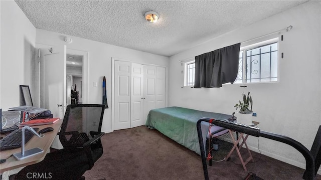 carpeted bedroom with a textured ceiling and a closet