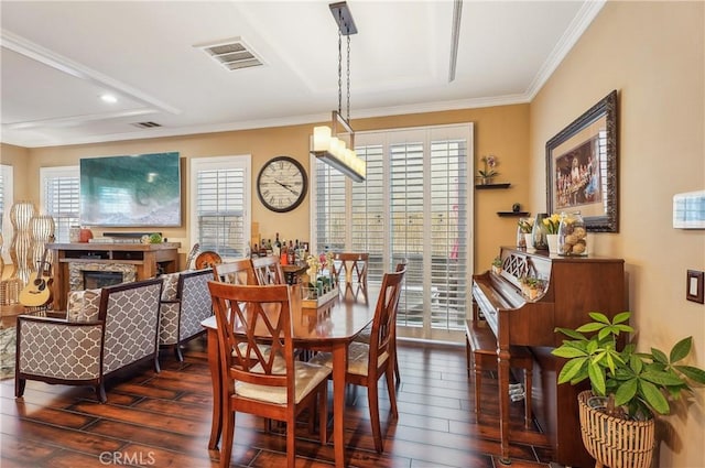 dining room with a wealth of natural light, ornamental molding, and dark hardwood / wood-style floors