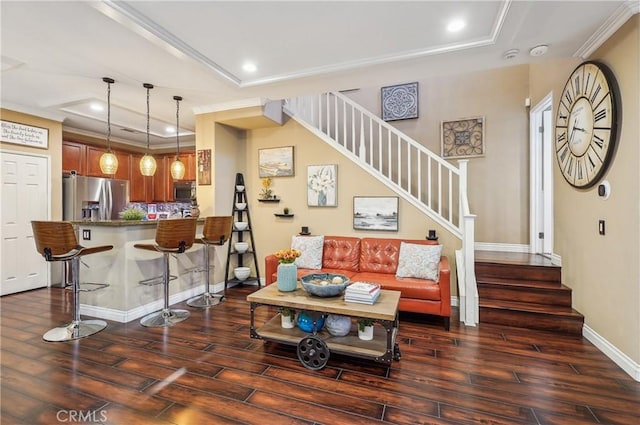 living room featuring dark hardwood / wood-style flooring, a tray ceiling, and crown molding