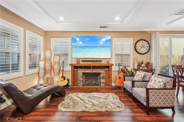 living room with crown molding, dark hardwood / wood-style floors, and a raised ceiling