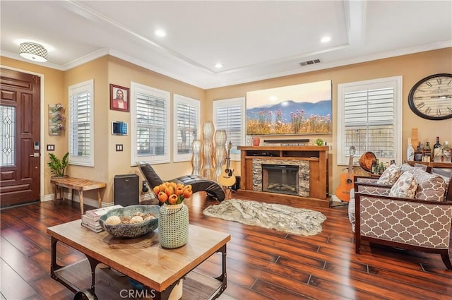 sitting room with crown molding, a stone fireplace, and dark hardwood / wood-style flooring