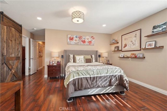 bedroom with dark hardwood / wood-style floors and a barn door