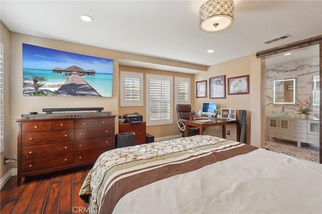 bedroom featuring dark hardwood / wood-style floors and ensuite bath