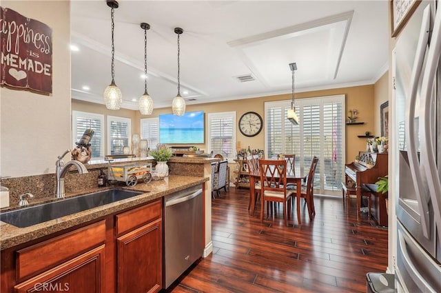 kitchen with pendant lighting, sink, stainless steel appliances, and stone counters