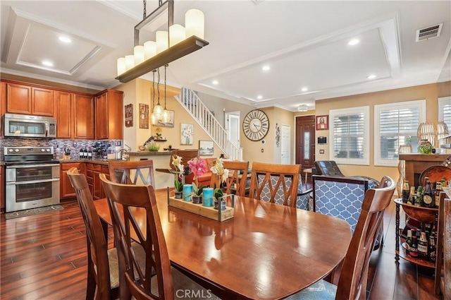 dining room with crown molding and dark hardwood / wood-style flooring