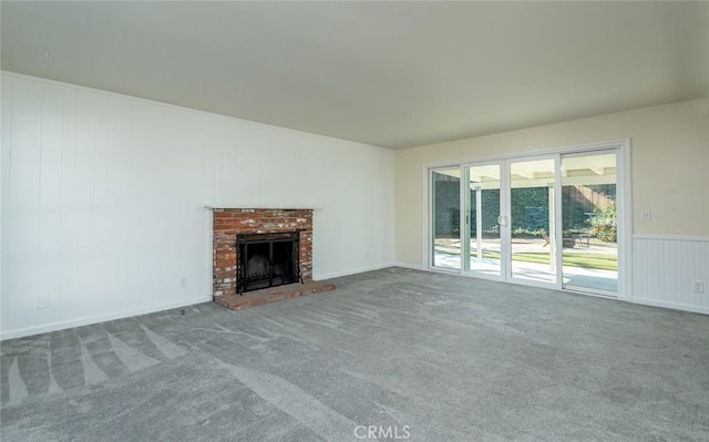 unfurnished living room with a brick fireplace and carpet floors