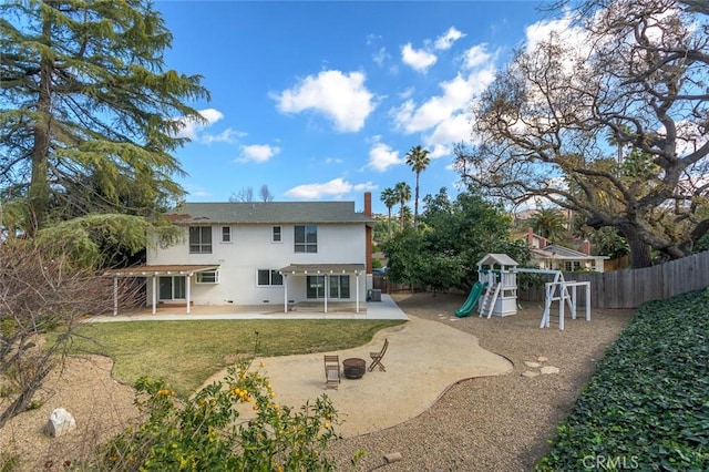 back of property with a patio, a playground, and a lawn