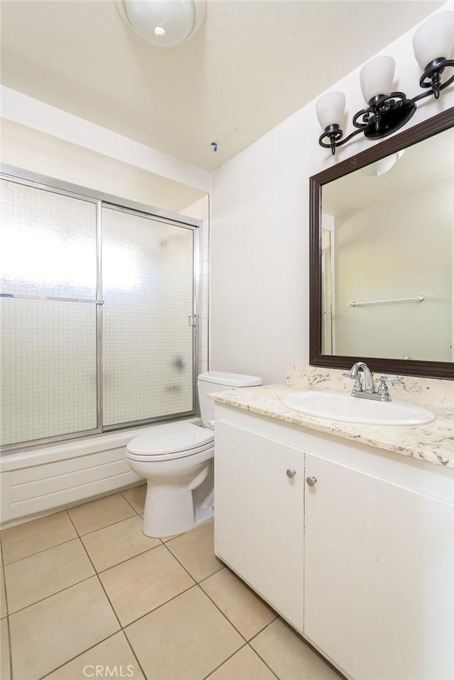 full bathroom with vanity, toilet, bath / shower combo with glass door, and tile patterned floors