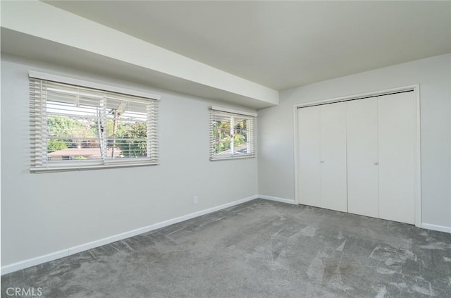 unfurnished bedroom with a closet, carpet, and multiple windows