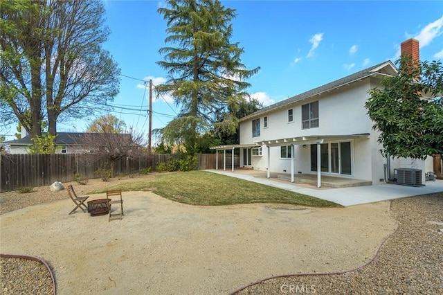 back of house with an outdoor fire pit, a yard, cooling unit, and a patio