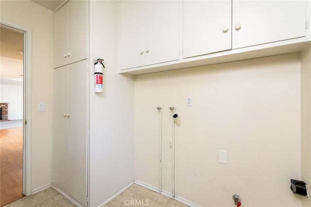 clothes washing area featuring cabinets