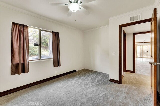 unfurnished room featuring ornamental molding, light carpet, and ceiling fan