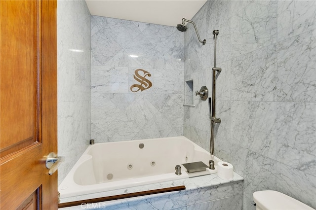 bathroom with toilet and tiled shower / bath