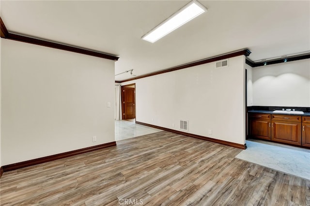 unfurnished room featuring crown molding and light hardwood / wood-style floors