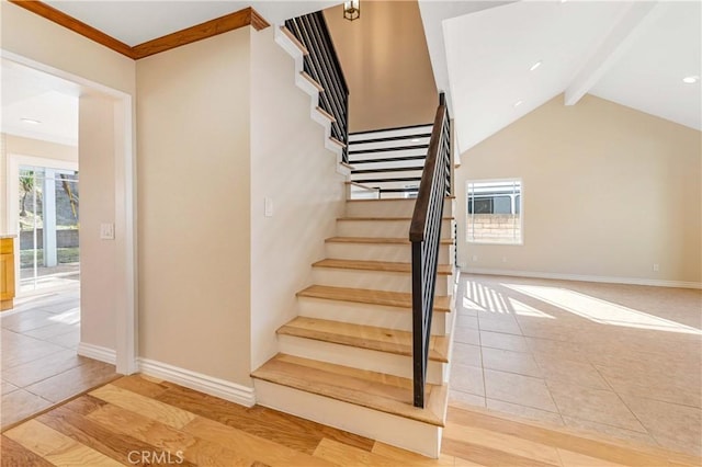 stairway with a healthy amount of sunlight, tile patterned floors, and lofted ceiling with beams