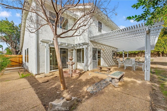 rear view of property featuring a patio and a pergola