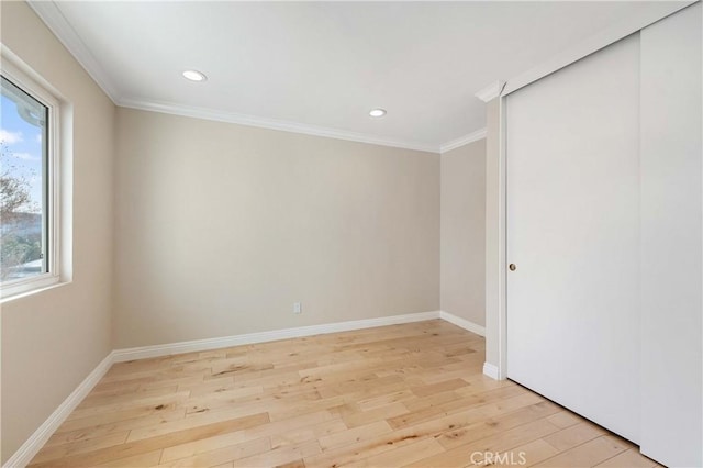 empty room featuring crown molding and light hardwood / wood-style floors