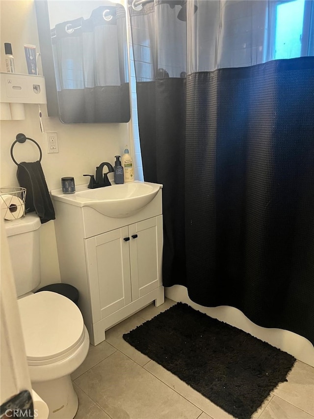 bathroom featuring tile patterned flooring, vanity, curtained shower, and toilet