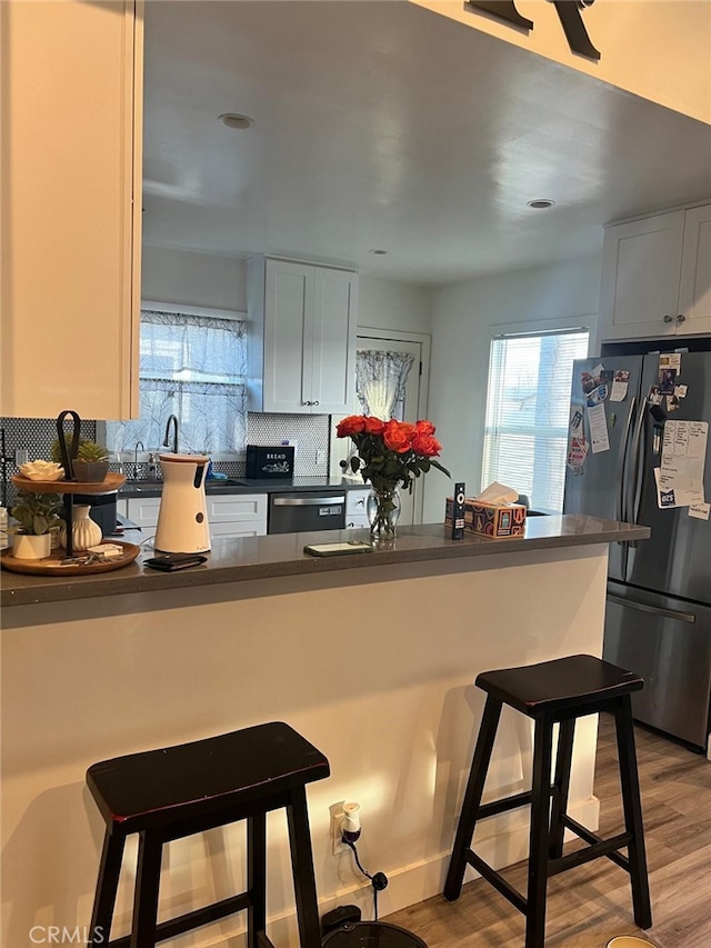 kitchen featuring white cabinetry, appliances with stainless steel finishes, and kitchen peninsula