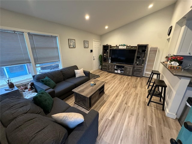 living room featuring vaulted ceiling and light wood-type flooring