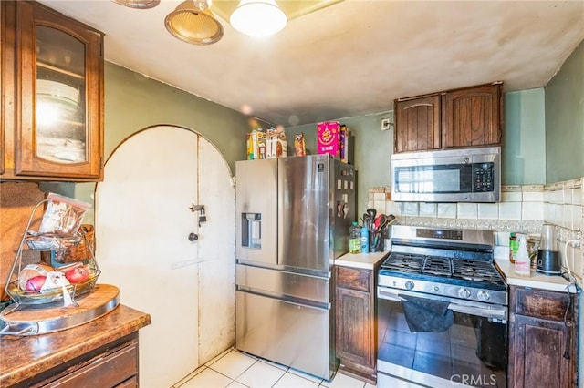 kitchen featuring light tile patterned floors, backsplash, and appliances with stainless steel finishes