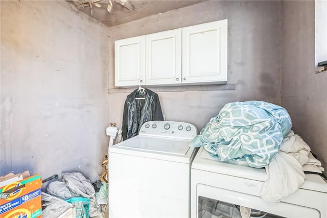 laundry room with separate washer and dryer and cabinets