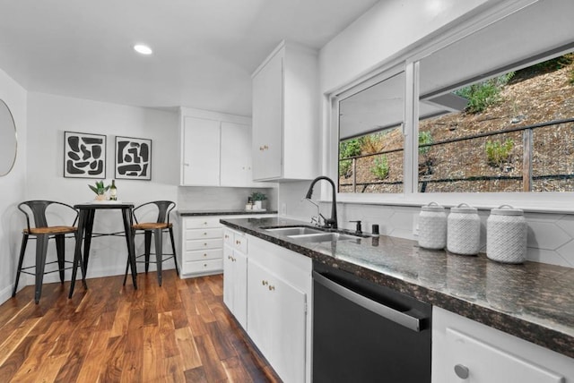 kitchen with sink, white cabinetry, dishwasher, and dark stone counters