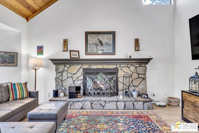 living room featuring wooden ceiling, a fireplace, wood-type flooring, and high vaulted ceiling