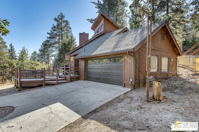 view of property exterior with a garage and a deck