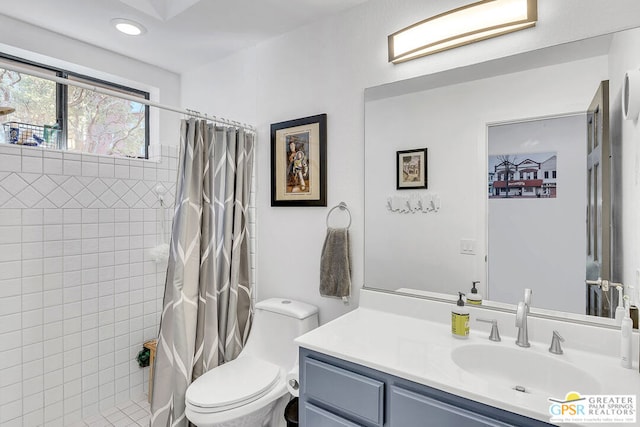 bathroom with toilet, vanity, and curtained shower