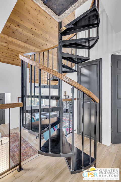 staircase featuring high vaulted ceiling, wood-type flooring, and wood ceiling