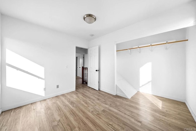 unfurnished bedroom featuring light wood-type flooring and a closet