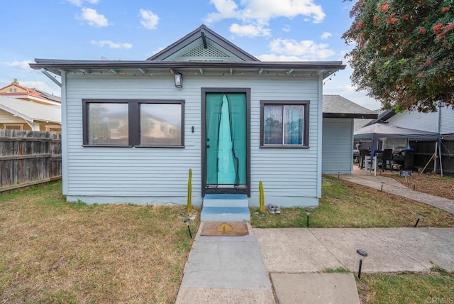 bungalow-style home with a front yard