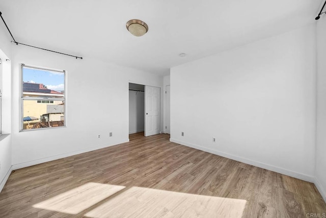 unfurnished bedroom with a closet and light hardwood / wood-style floors