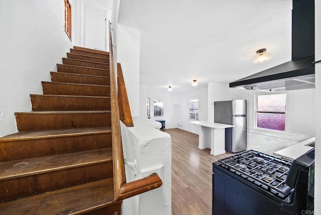 stairs featuring vaulted ceiling and wood-type flooring