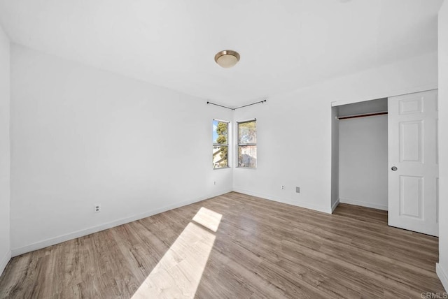 unfurnished bedroom featuring hardwood / wood-style floors and a closet