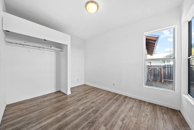 unfurnished bedroom featuring hardwood / wood-style floors and a closet