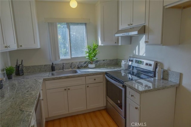 kitchen featuring stainless steel range with electric cooktop, light hardwood / wood-style floors, light stone countertops, white cabinets, and sink