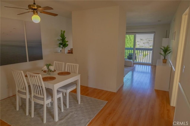 dining area with ceiling fan and light wood-type flooring