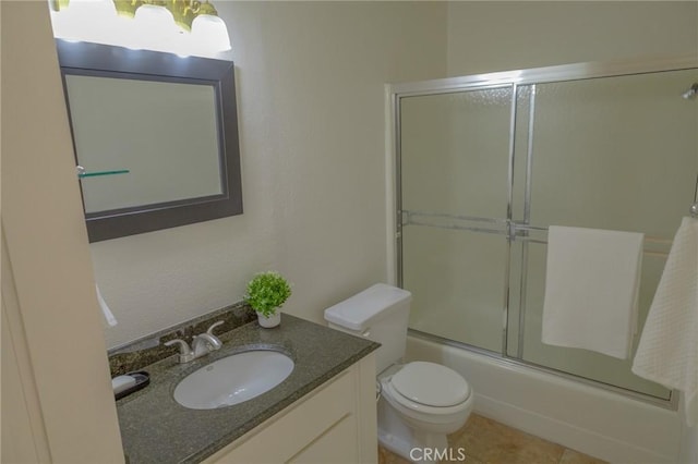 full bathroom featuring toilet, tile patterned flooring, enclosed tub / shower combo, and vanity