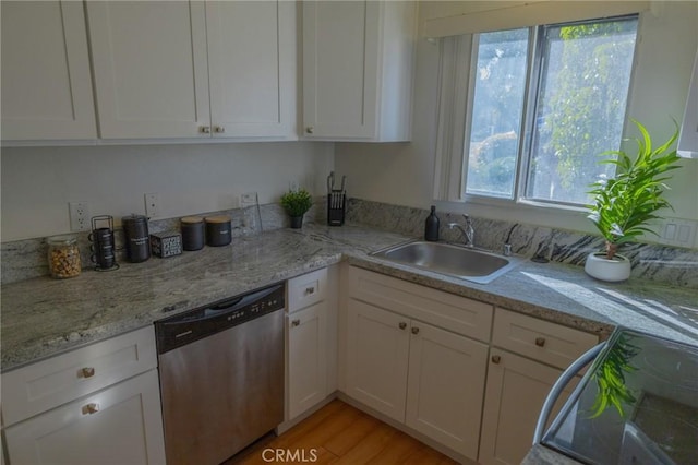 kitchen with dishwasher, sink, light hardwood / wood-style flooring, white cabinets, and range