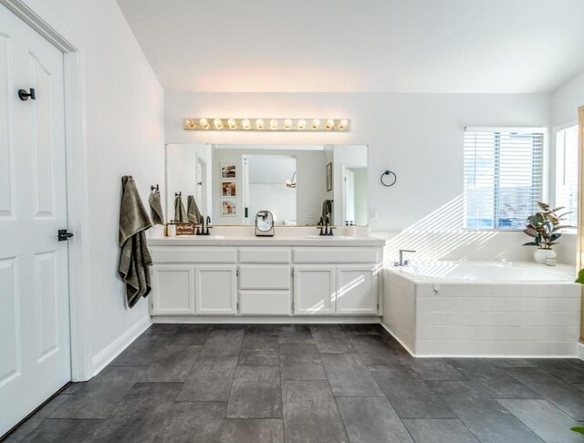 bathroom featuring vanity and a relaxing tiled tub