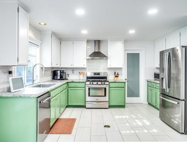 kitchen featuring appliances with stainless steel finishes, wall chimney exhaust hood, white cabinetry, sink, and green cabinets