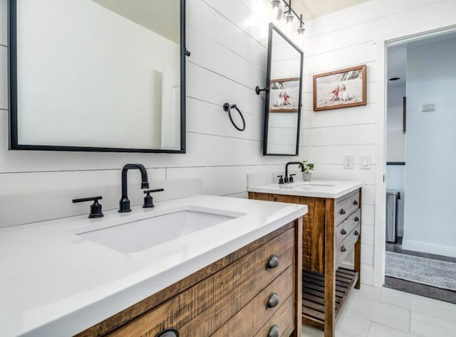 bathroom with tile patterned floors, vanity, and wood walls