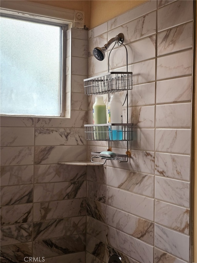 bathroom featuring a healthy amount of sunlight and a tile shower