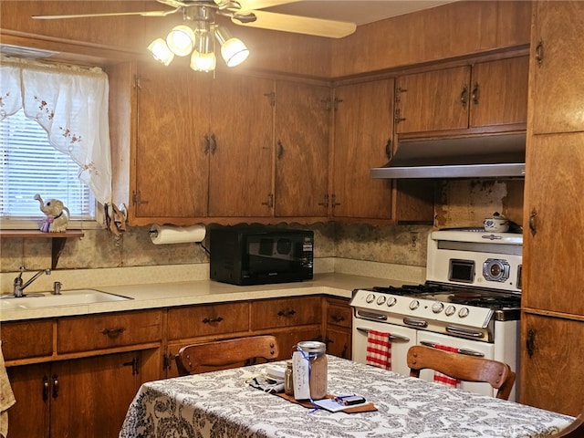 kitchen with double oven range, ceiling fan, and sink