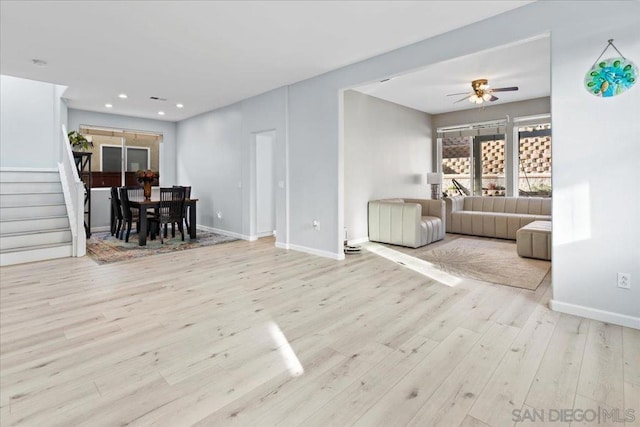 living room with ceiling fan and light hardwood / wood-style flooring