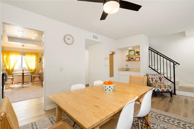 dining room featuring sink, light hardwood / wood-style floors, and ceiling fan