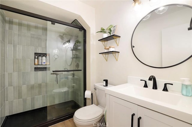 bathroom with toilet, a shower with shower door, and vanity