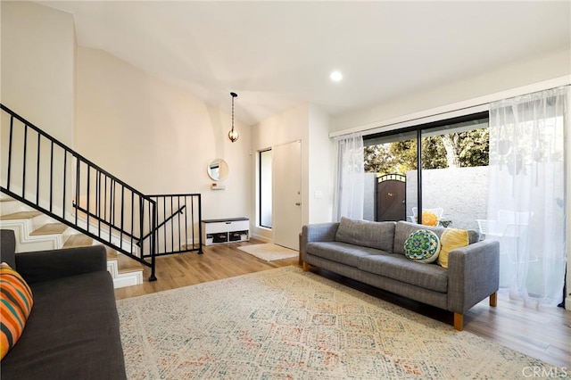 living room with light hardwood / wood-style floors and vaulted ceiling